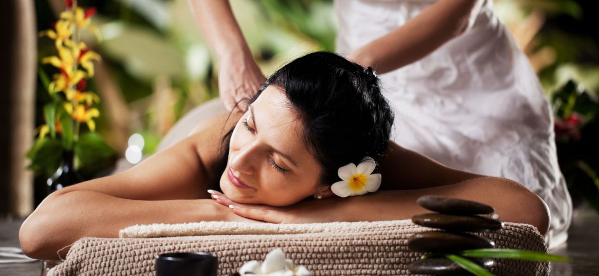 Woman getting a massage at tropical spa